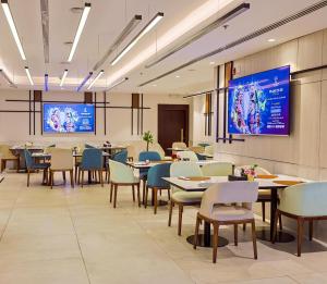 a dining room with tables and chairs and a projection screen at Ayass Hotel in Amman