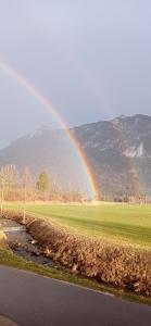 a rainbow over a field next to a river at Gästehaus Barbara Schwaiger - Chiemgau Karte in Inzell +27 photos