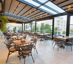 an empty restaurant with tables and chairs and windows at Ayass Hotel in Amman