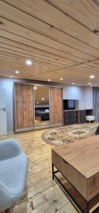 a living room with a wooden ceiling and a couch and a table at B apartment Рахів in Rakhiv