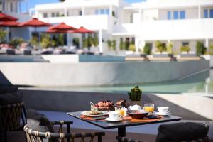 a table with food and drinks on top of a patio at Santorini Heart Hotel & Spa in Fira