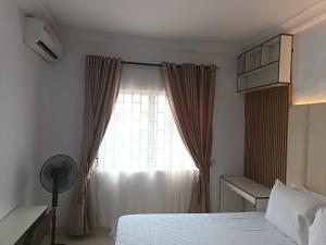 a bedroom with a white bed and a window at Kbazz apartments in Ibadan +3 photos