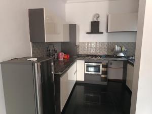 a kitchen with white cabinets and a stainless steel refrigerator at Kbazz apartments in Ibadan