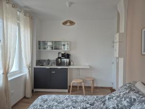 a bedroom with a bed and a small kitchen at St FURSY 2 in Péronne