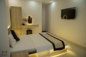 a bedroom with a bed with a television on the wall at Bich Thu Hotel in Ho Chi Minh City