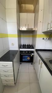 a small kitchen with a stove and a sink at Kamana Studio in Luanda