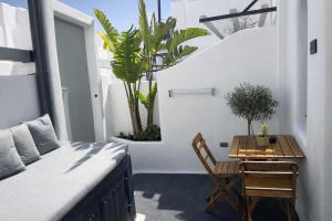 a bedroom with a bed and a table and chairs at Tiara Suites Fira - Cycladic & Cave in Fira