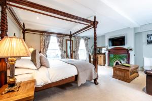 ein Schlafzimmer mit Himmelbett und Kamin in der Unterkunft The Peppermill Boutique Hotel in Devizes