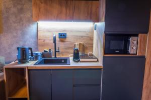 a small kitchen with a sink and a microwave at Sky Apartman 2 in Kučevo +4 photos