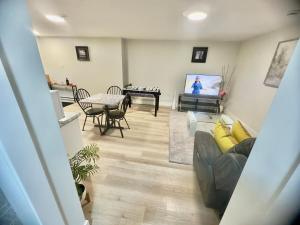 a living room with a couch and a flat screen tv at Airport Haven Getaway in Dieppe