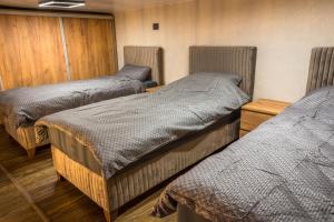 a room with three beds in a room at Sky Apartman 2 in Kučevo