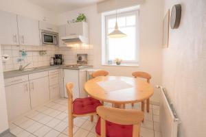 a small kitchen with a wooden table and chairs at Boje 15 in Schillig