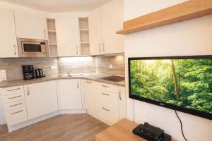 a kitchen with a large flat screen tv on the wall at Boje 5 in Schillig