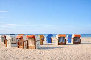 a row of beach huts on a sandy beach at Boje 5 in Schillig