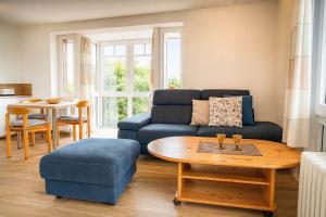 a living room with a blue couch and a table at Boje 21 in Schillig