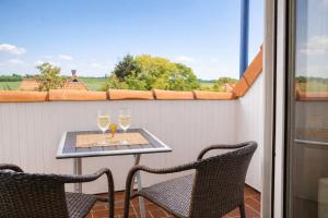 a balcony with a table and two glasses of wine at Boje 21 in Schillig