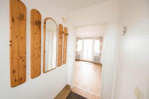 a hallway with three mirrors on a wall at Boje 21 in Schillig