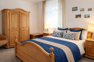 a bedroom with a large bed with blue pillows at Boje 7 in Schillig