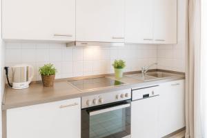 a kitchen with white cabinets and a sink at Boje 7 in Schillig +16 photos
