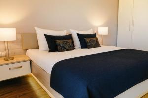 a bedroom with a large bed with black and white pillows at Vogelkieker in Schillig