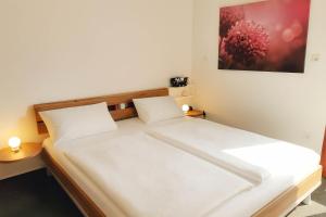 ein Schlafzimmer mit einem großen Bett mit weißer Bettwäsche in der Unterkunft Granata in Schillig