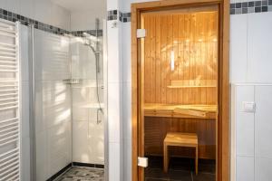 ein Badezimmer mit Dusche und Holztür in der Unterkunft Granata in Schillig + 17 Fotos
