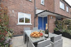 a table with a bowl of food and a bottle of wine at Fossgate Luxury Duplex City Centre Apartment with Free Parking in York