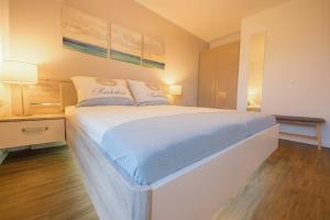 a bedroom with a large white bed in a room at Strandnah in Schillig