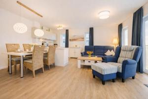 a living room with a blue couch and a table at Leuchtfeuer in Schillig