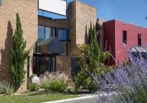 a brick house with a glass facade at The Originals City, Hotel Novella Confort, Nantes Est in Carquefou