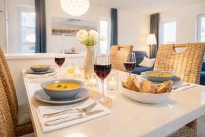 a table with two glasses of wine and a bowl of food at Leuchtfeuer in Schillig +16 photos