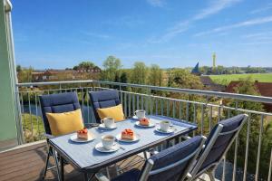 a table and chairs on a balcony with a view at Leuchtfeuer in Schillig