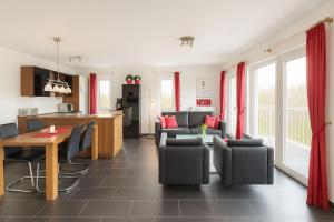 a kitchen and living room with a table and chairs at Waterkant in Schillig
