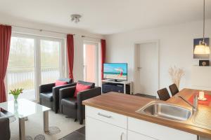 a kitchen and living room with a couch and a table at Waterkant in Schillig