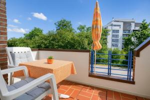 a balcony with a table and chairs and an umbrella at Boje 9 in Schillig