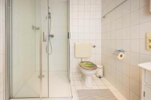 a bathroom with a toilet with a green seat at Boje 9 in Schillig +16 photos