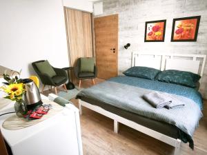 a bedroom with a bed and two chairs and a table at Vila Olivín - Private rooms with bathroom in Banská Bystrica