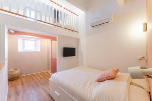 a white bedroom with a bed and a window at Lavagnou Duplex in La Ciotat
