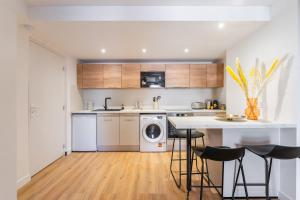 a kitchen with a washer and dryer and a table at Lavagnou Duplex in La Ciotat +5 photos