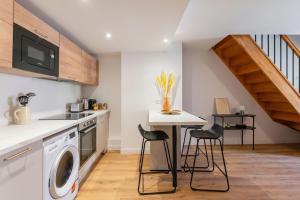 a kitchen with a washing machine and a table with stools at Lavagnou Duplex in La Ciotat