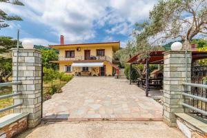 an exterior view of a house with a driveway at Unique Filoxenia! in Skopelos Town