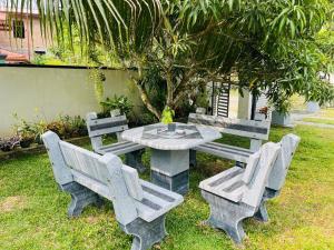 a picnic table with four benches and a table and chairs at Dream villa in Imaduwa +5 photos