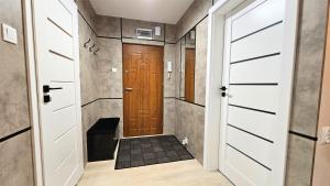 a hallway with a wooden door and a tile floor at Piękna 20 Residence in Łomża
