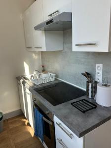 a kitchen with white cabinets and a stove top oven at Studio avec vue sur le Château in Azay-le-Rideau
