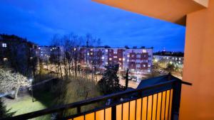 a balcony with a view of a city at night at Piękna 20 Residence in Łomża