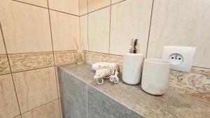 a corner of a bathroom with a counter with a bottle and apotion at Piękna 20 Residence in Łomża +4 photos