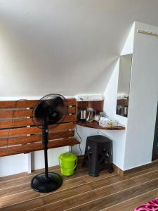 a room with a fan next to a wooden bench at Casita Greens in Kondotti