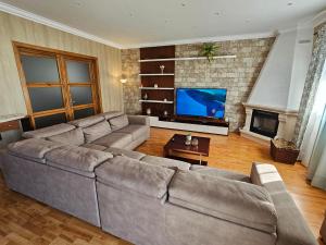 a living room with a large couch and a tv at Santa Maria Goldcrest House in Vila do Porto