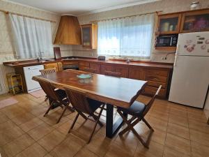 a kitchen with a wooden table and a refrigerator at Santa Maria Goldcrest House in Vila do Porto