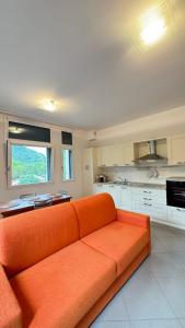 an orange couch sitting in a kitchen with a window at Dimora delle Terme in Porretta Terme